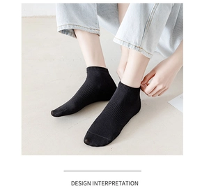 Detail of black cotton socks featuring ribbed cuffs and reinforced arch support