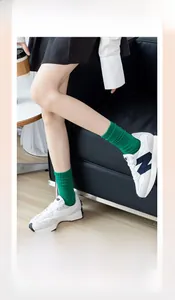 Dettaglio calzini in cotone a coste verde con polsino elastico e scarpe da ginnastica