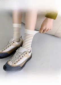 Close-up of brown striped mid-calf socks with cute bear embroidery and breathable cotton texture