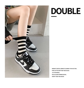 Detail of black and white striped cotton mid-tube socks showing breathable knit texture