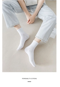Close-up of white ribbed crew socks in breathable combed cotton on model feet