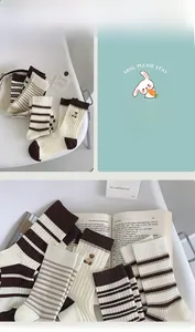 Close-up of brown striped cotton socks with cute bear embroidery and ribbed cuffs
