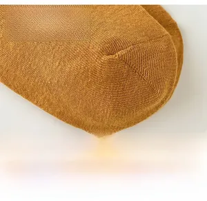 Nahaufnahme der ingwergelben Strickstruktur und feinen Nähte an den Baumwollkniestrümpfen