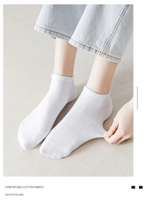 Close-up of white breathable cotton sports socks showing elastic fit and mesh texture