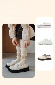 Détail de chaussettes mi-mollet en dentelle avec broderie florale et chaussures en cuir beige