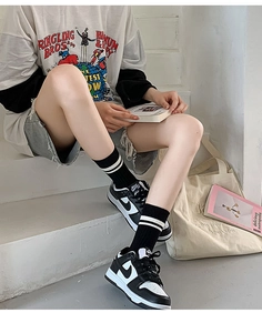 Close-up of black and white striped cotton socks with embroidered R detail in street style