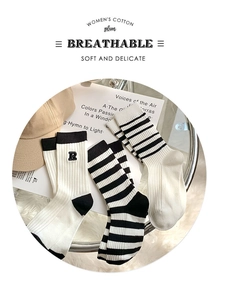 Detail of cotton crew socks showing black stripes and R embroidery on ribbed fabric