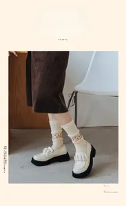 Détail de broderie tulipe rouge sur chaussettes en coton ajourées avec mocassins