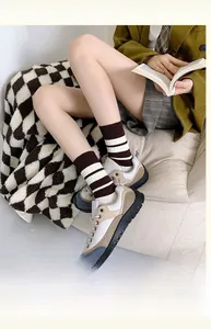 Detail of brown striped cotton socks with jacquard craft and white stripes on model
