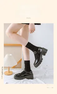 Detail of black glossy Mary Jane shoes with thick soles and vertical striped cotton socks