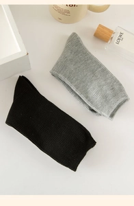 Close-up of black and grey ribbed mid-calf cotton socks with minimalist lifestyle props