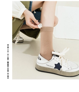 Detail of coffee brown ribbed socks with smile patch paired with vintage star sneakers
