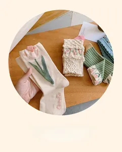 Détail de la broderie tulipe et dentelle au crochet sur chaussettes en coton peigné