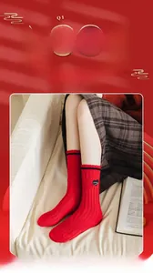 Detail of red cotton knit mid-calf socks with heart patch and black ribbed cuffs