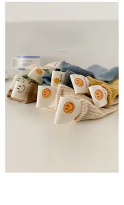 Detail of colorful ribbed cotton socks with smiley face fabric labels on the cuffs