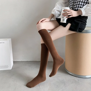 Braune Kniestrümpfe aus Baumwolle an einem Modell in minimalistischem Studio-Set