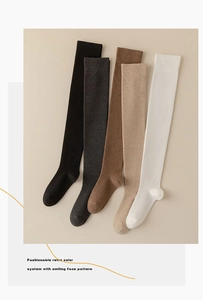 Flat lay of five pairs of vintage style over-knee socks in assorted solid neutral colors