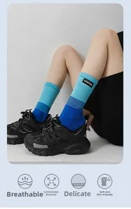 Détail de chaussettes dégradées bleues avec tricot respirant et revers élastiques