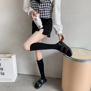 Schwarze Kniestrümpfe im japanischen Stil mit Ledersandalen und doppelter Schnalle