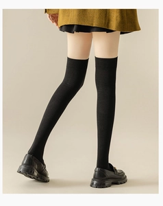 Close-up of black thigh-high knit socks with vertical ribs and elasticated cuffs