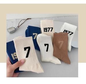 Detail of retro 1977 numeric pattern on ribbed cotton crew socks in multiple colors