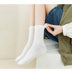 Detailed view of white ribbed mid-calf socks with cute smile patch and striped texture