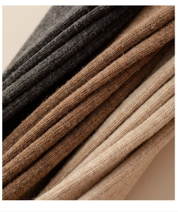 Detail of ribbed knit texture on over-the-knee socks in charcoal, brown, and beige colors