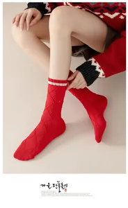 Detail of red cotton knit socks featuring white rabbit embroidery and stripe pattern