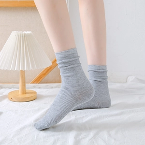 Minimalist grey cotton crew socks for women featuring a ribbed design in a cozy home setting
