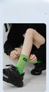Détail de chaussettes mi-hautes côtelées vert vif avec étiquette et baskets