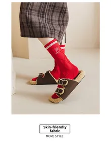Detail of red cotton socks with bunny embroidery and plush brown slippers