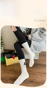 Détail de chaussettes blanches en coton avec texture côtelée et broderie lettre A