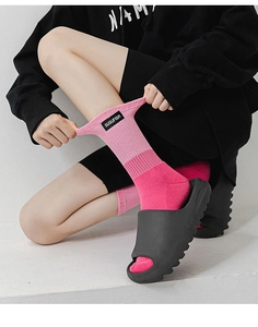 Détail de chaussettes de sport dégradées roses avec étiquette tissée et semelle bouclée