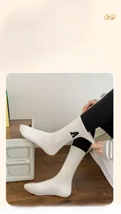 Détail de la chaussette élastique en coton blanc avec broderie de la lettre A noire
