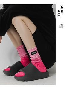 Détail de sandales noires avec chaussettes de sport roses et semelles crantées épaisses
