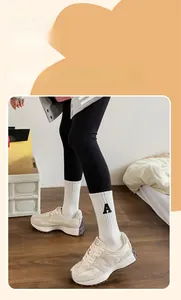 Détail de chaussettes de sport en coton blanc avec broderie lettre A noire et texture côtelée
