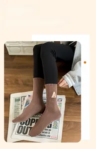 Détail de chaussette de sport en coton marron avec lettre A brodée et talon en forme de Y