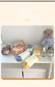 Détail de chaussettes d'hiver en polaire corail avec petits ours 3D et tons doux