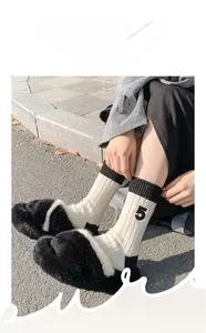 Close-up of elastic cuffs on wool blend socks featuring stylish number five embroidery