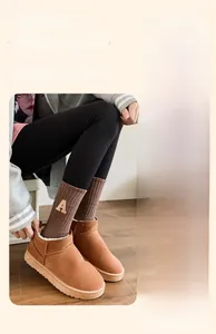 Gros plan de bottines de neige en daim marron avec doublure polaire et chaussettes en tricot