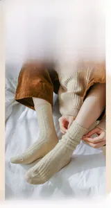 Detail shot of beige diamond knit wool socks featuring a soft textured argyle pattern