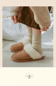 Detailed view of brown faux suede slippers with thick white plush lining and rubber soles