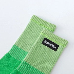 Chaussettes de sport côtelées vert fluo avec écusson logo sur fond blanc, style athlétique