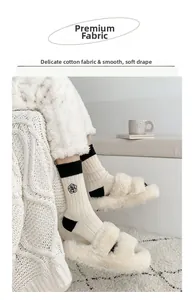 Detail of ivory wool socks with black camellia embroidery and ribbed texture finish