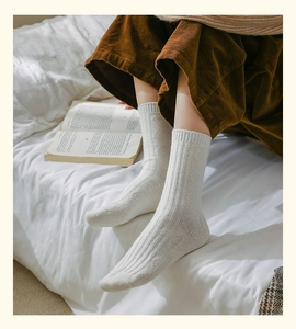 Close-up of white argyle wool-like socks with thick rib knit texture for winter warmth