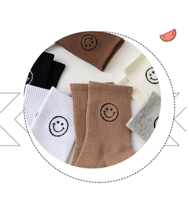 Close-up of ribbed cotton crew socks in assorted colors with smiley face embroidery