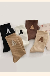 Détail de chaussettes en coton en cinq couleurs avec lettre A brodée style universitaire