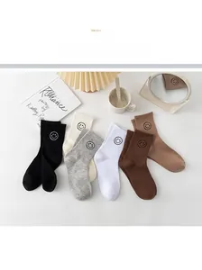 Detail shot of cotton socks with embroidered smiley face patterns in assorted colors