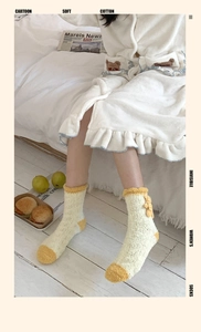 Détail de chaussettes d'intérieur en polaire corail avec nœud jaune et maille ondulée