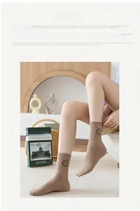 Detail of khaki ribbed cotton socks with black smiley face embroidery in a cozy setting